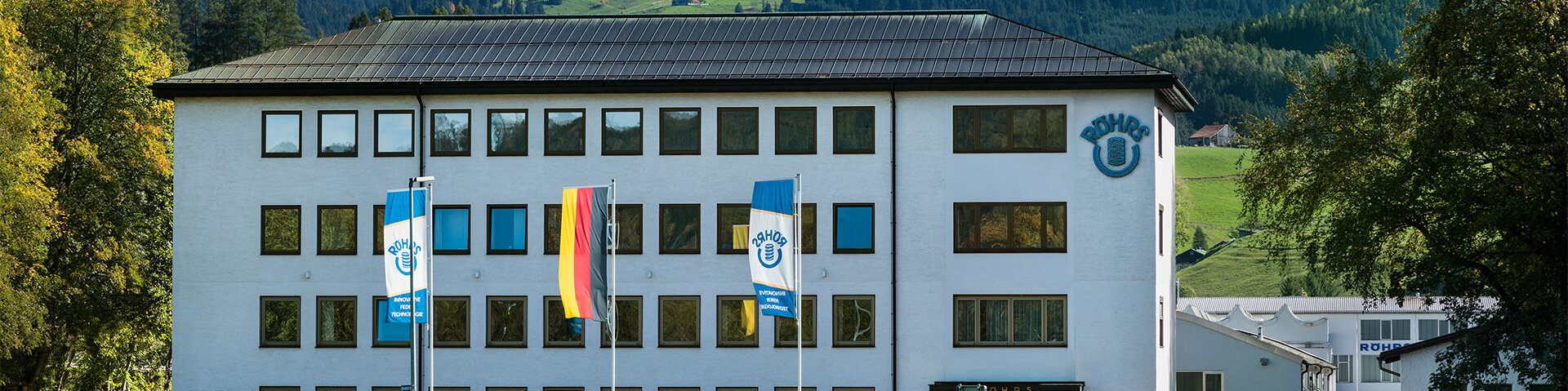Das Röhrs Verwaltungsgebäude in Sonthofen von vorne fotografiert mit den allgäuer Alpen im Hintergrund
